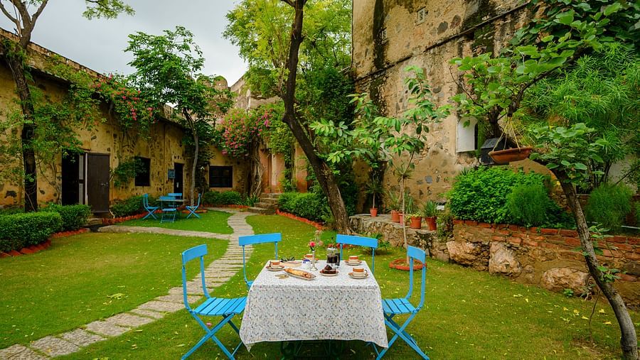 Hill Fort Kesroli 14th Century Alwar - image of a table with chairs on grass adjacent to a pathway