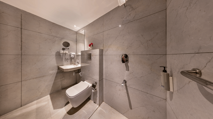 Lords Eco Inn bedroom with a large bed, a headboard, a ceiling fan, and simple wooden furniture.