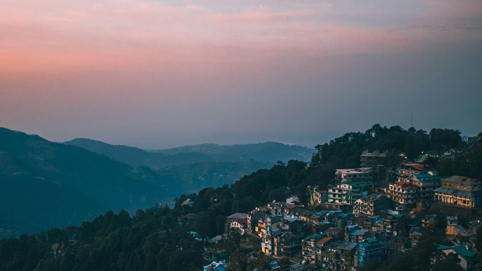 a hilly range on an evening with a beautiful sky with orange hues in the background in dalhousie