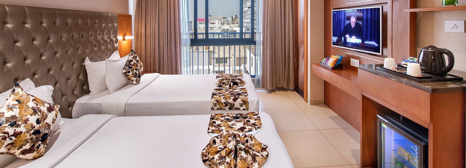 A comfortable hotel room with twin beds - SK Lords Inn Ahmedabad