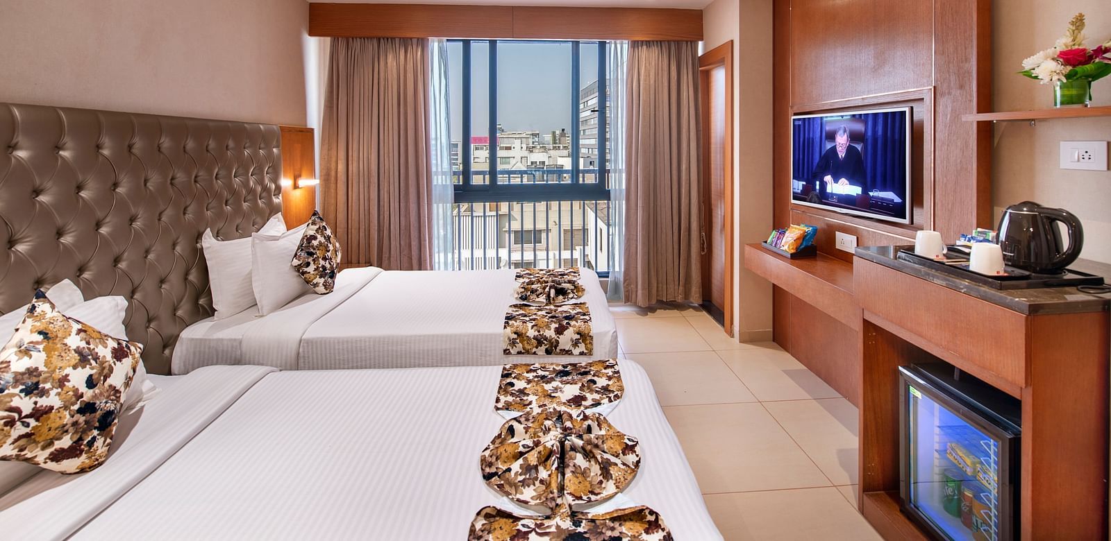 A comfortable hotel room with twin beds - SK Lords Inn Ahmedabad