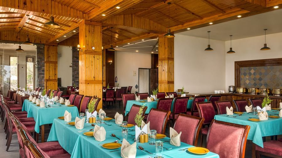  A spacious and well-lit restaurant with neatly set dining tables, complemented by rustic wooden decor, providing a welcoming atmosphere for guests - Digantaa Resort in Mukteshwar