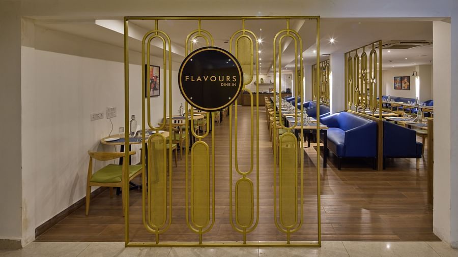 A dining area entrance features wooden floors, blue couches, and a sign with the area name in elegant lettering - Grand Continent, Brookefield