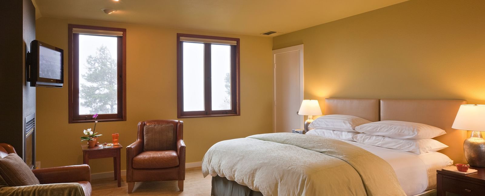 A cozy hotel room with soft lighting, comfortable furniture, and a relaxing ambiance, perfect for a restful stay - Brewery Gulch Inn & Spa