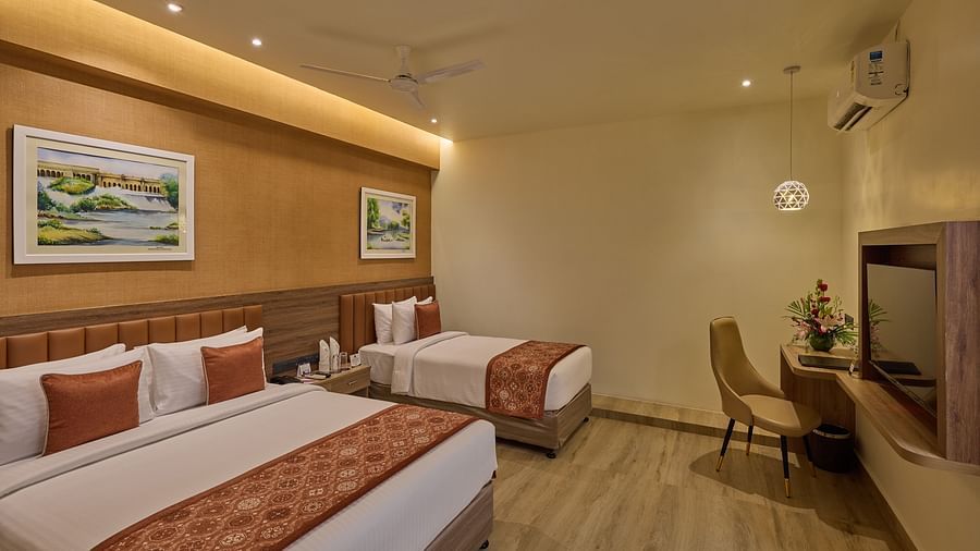 Another angle of our Family Room with a queen size bed and an extra bed placed in front of a wall-mounted television