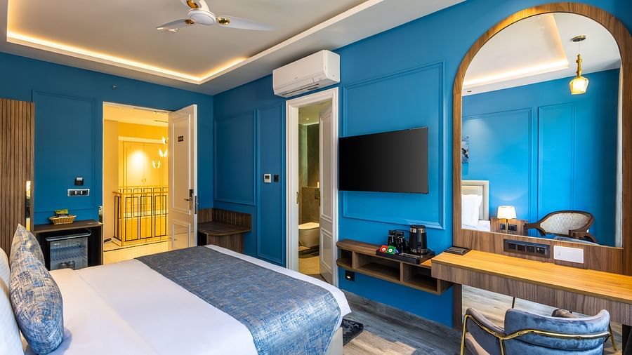 A full view of a bedroom with a bed and mirror on the wall | Renest Calangute, Goa