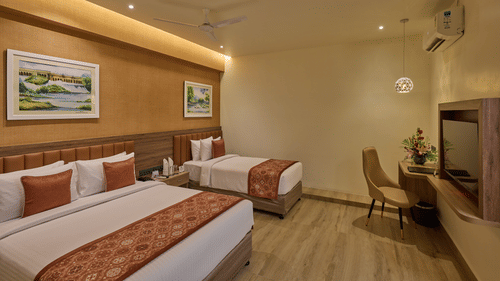 Another angle of our Family Room with a queen size bed and an extra bed placed in front of a wall-mounted television