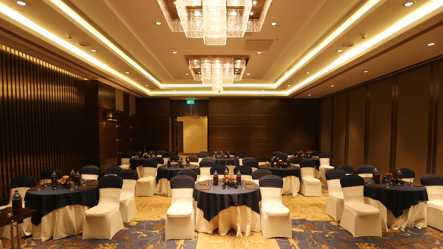  A hall with chairs and tables arranged for an event at Pride Plaza, New Delhi.
