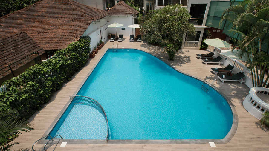 Outdoor swimming pool with sun loungers at Ocean Palms Hotel Goa