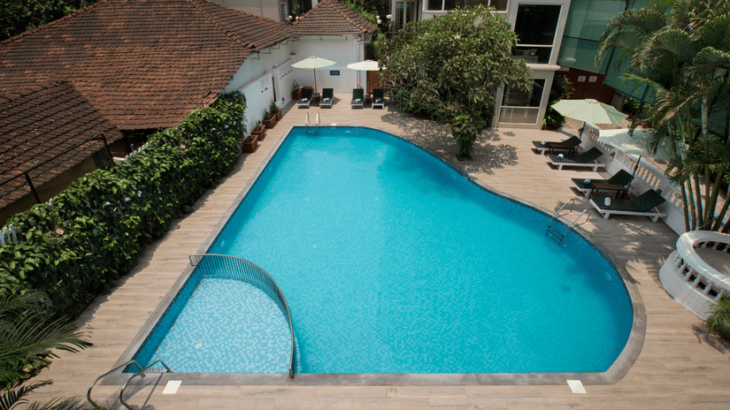 Outdoor swimming pool with sun loungers at Ocean Palms Hotel Goa