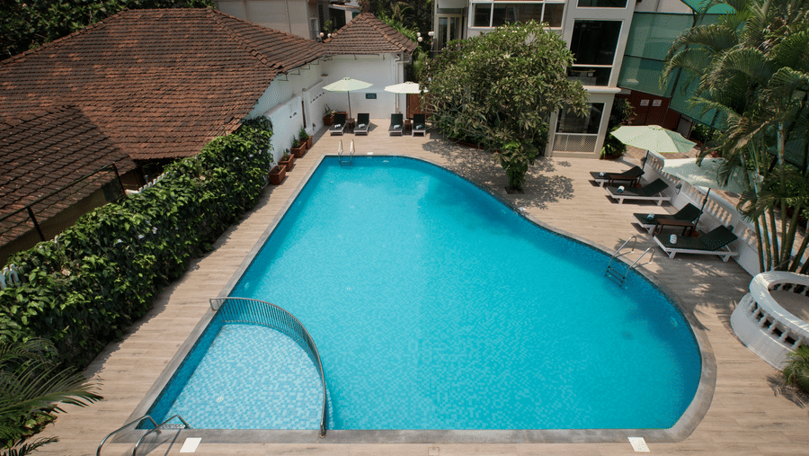 Outdoor swimming pool with sun loungers at Ocean Palms Hotel Goa