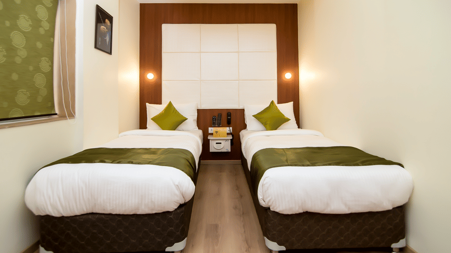 The Onyx twin room showing two single beds placed side by side, with bed linens, bedside tables, lighting, and wooden flooring.