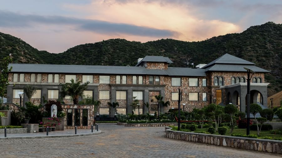 A different angle of the main resort building, with the driveway in the foreground and a warm, sunset-coloured sky.