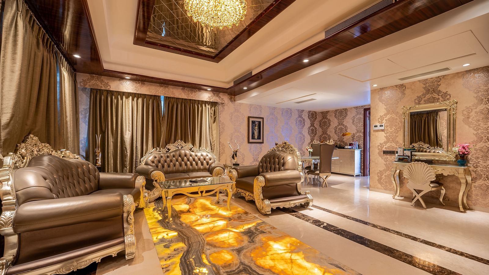 Presidential Suite with a separate living area, featuring cushioned furniture and warm lighting at Crescent Spa & Resort, Indore