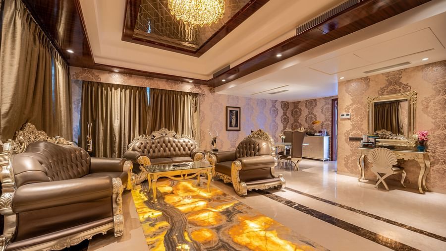 Presidential Suite with a separate living area, featuring cushioned furniture and warm lighting at Crescent Spa & Resort, Indore