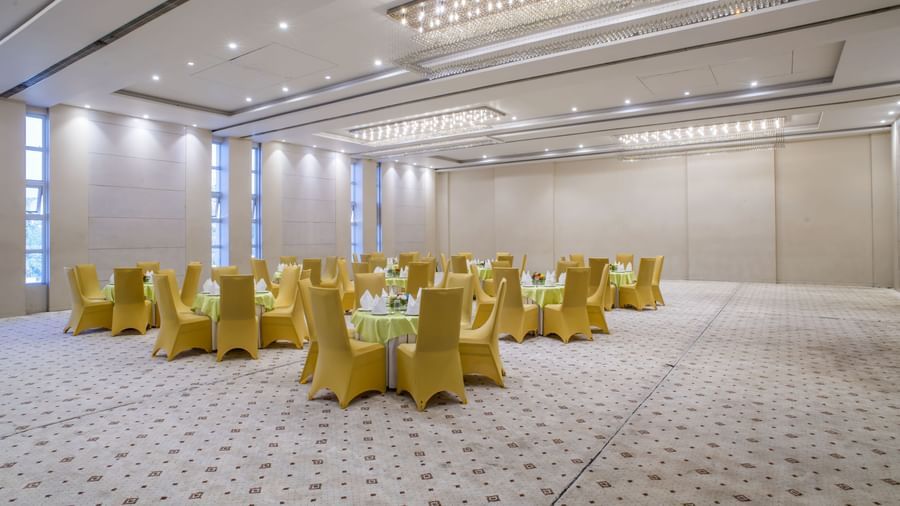 Another view of the large meeting room at The Citi Residenci Hotel, Asansol with golden chairs and textured flooring.