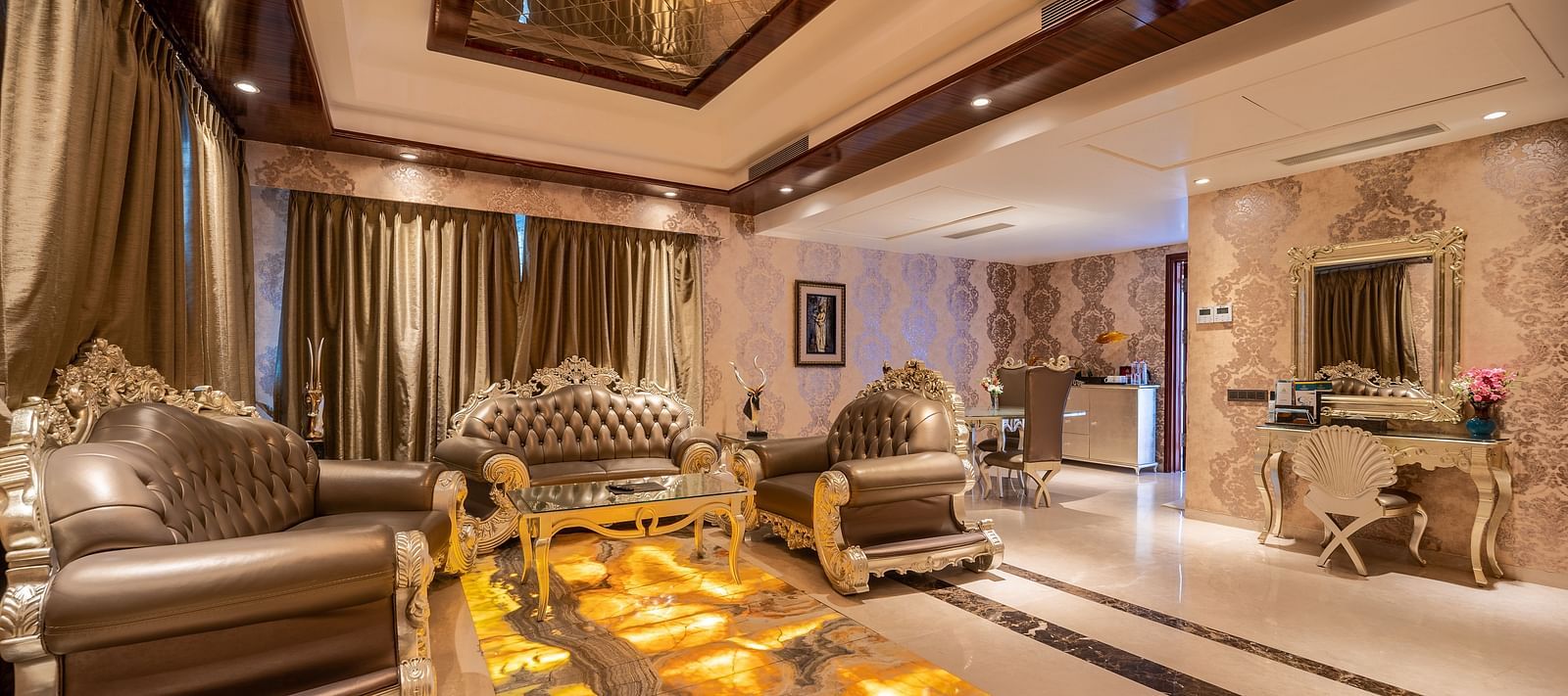 Presidential Suite with a separate living area, featuring cushioned furniture and warm lighting at Crescent Spa & Resort, Indore
