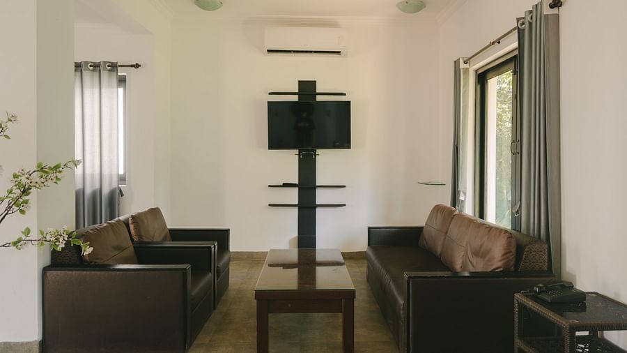 Cozy living room with a comfortable sofa and a TV in the Three BHK Deluxe Villa at Richmonde Ananta Elite, Goa.