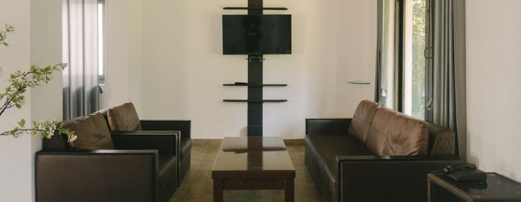 Cozy living room with a comfortable sofa and a TV in the Three BHK Deluxe Villa at Richmonde Ananta Elite, Goa.