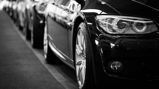 Row of luxury cars lined up, captured from a low-angle perspective.