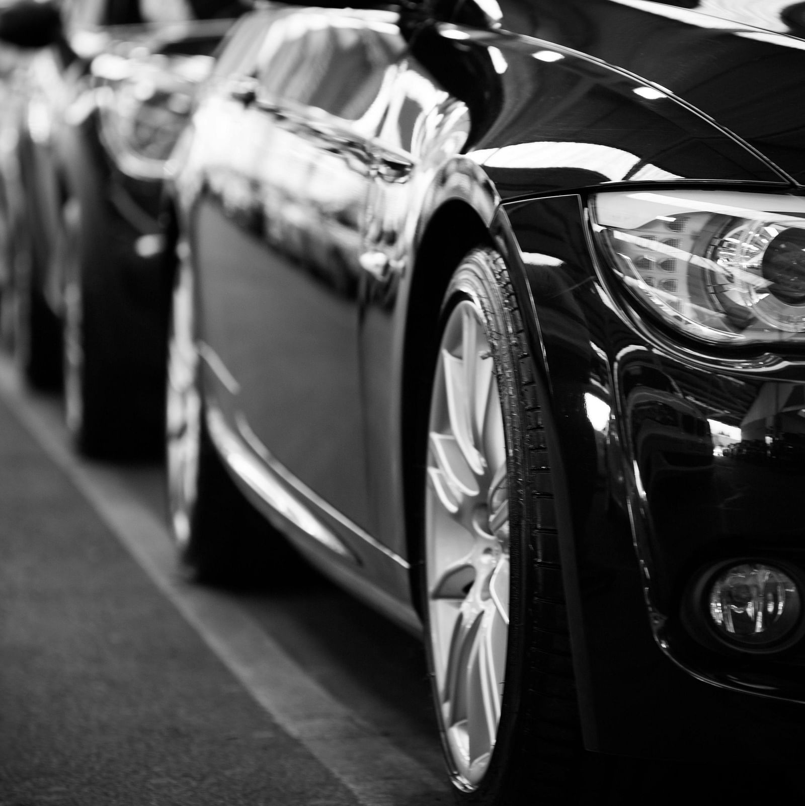 Close up image of a car parked with several other in line.