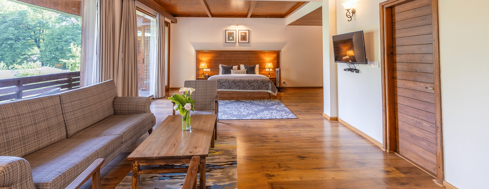 the xclusive room with lavish wooden interiors with a sofa and queen bed at Bedzzz Xclusiv Baikunth