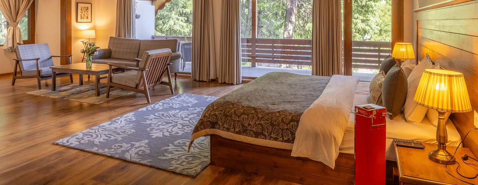 xclusiv room with queen bed and a sofa setting with lavish wooden interiors at Bedzz Xclusiv Baikunth, Manali