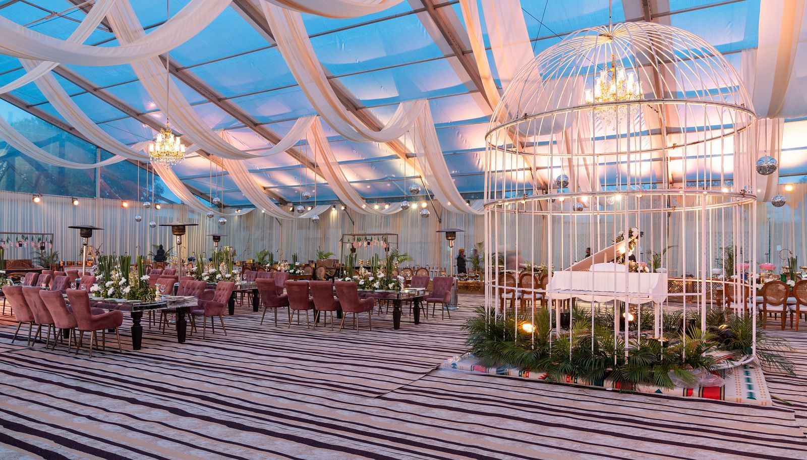 Lavish decoration of an event hall with chairs placed around a table at Nirvana Luxury Hotel, Ludhiana.