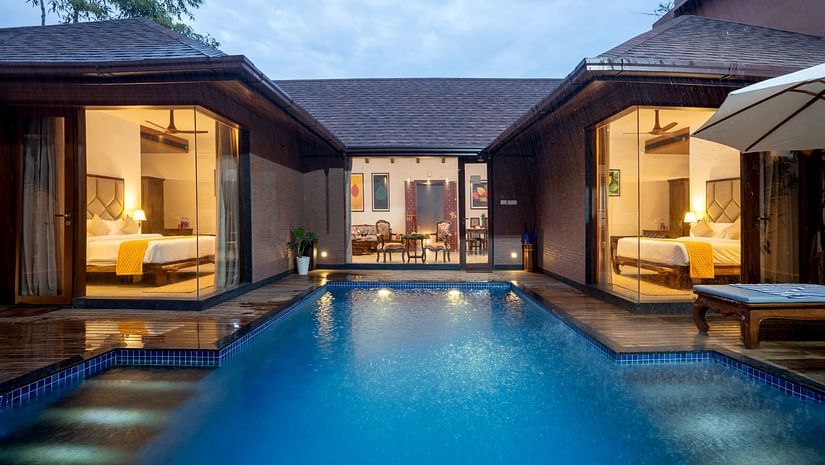 Uday Backwater Resort featuring a swimming pool with stairs leading to Pool Villa and Premium Pool Villa on a cloudy day