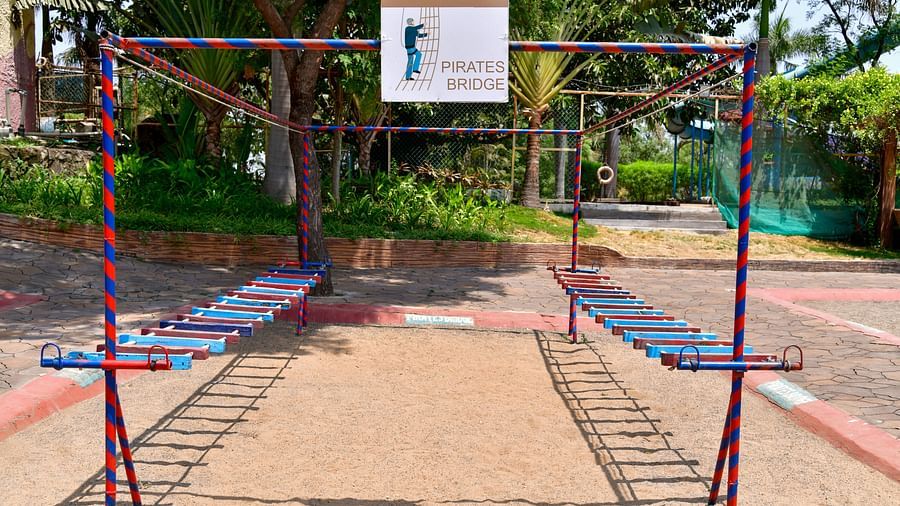 Outdoor playground with traditional swings set in a park under clear blue skies | Diamond Parks, Pune