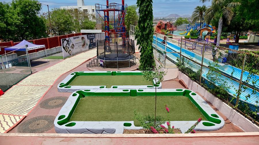 Outdoor mini golf course with lush greenery and blue ocean in the background |  Diamond Parks, Pune