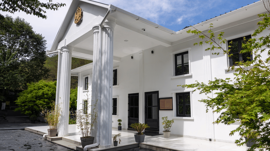 The facade of Mandalay, with trees in the surroundings and sky in the backdrop.