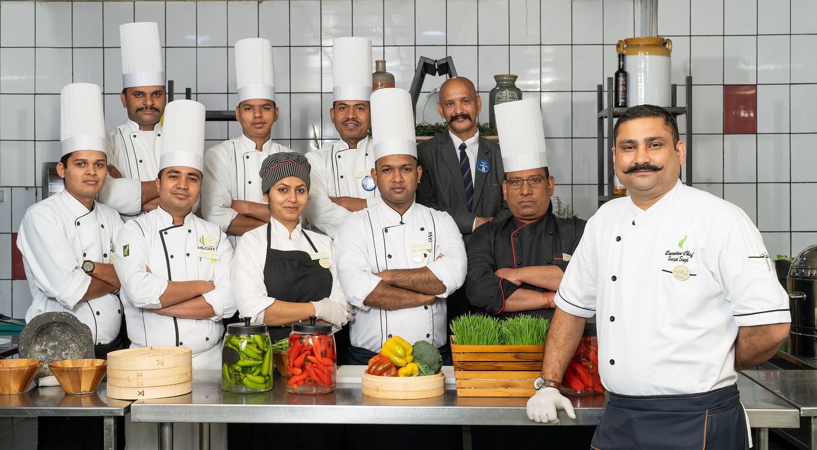 A group of chefs posing for a photo in a kitchen at Nirvana Luxury Hotel, Ludhiana.