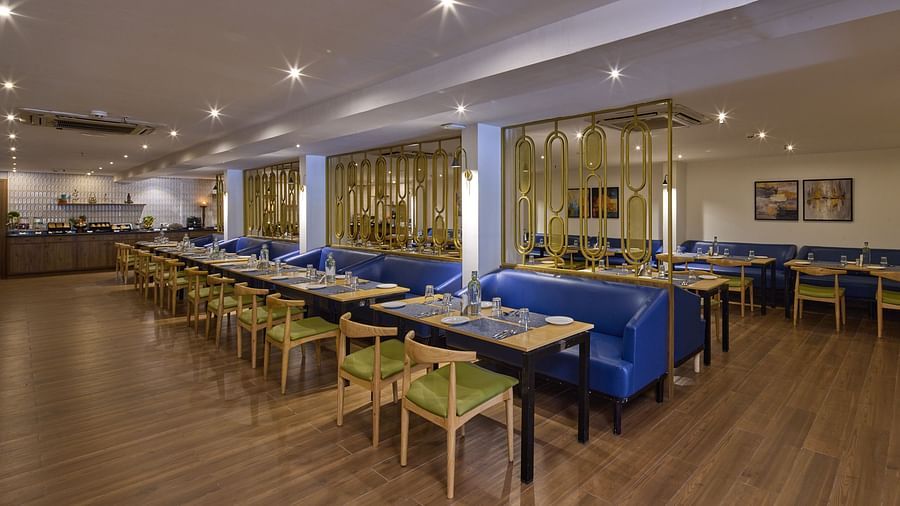 A wide angle shot of Flavours, our multi-cuisine restaurant in Bengaluru with ambient lighting and cosy seating - Grand Continent, Brookefield