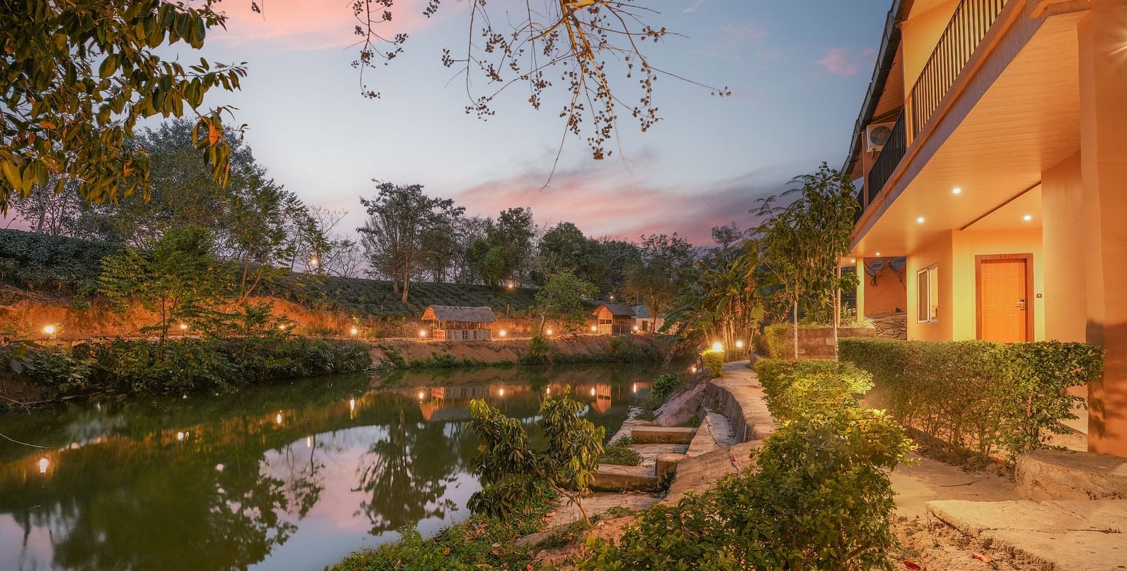Lake view with warm lighting at Summit Green Lake Tea Resort & Spa, Kaziranga
