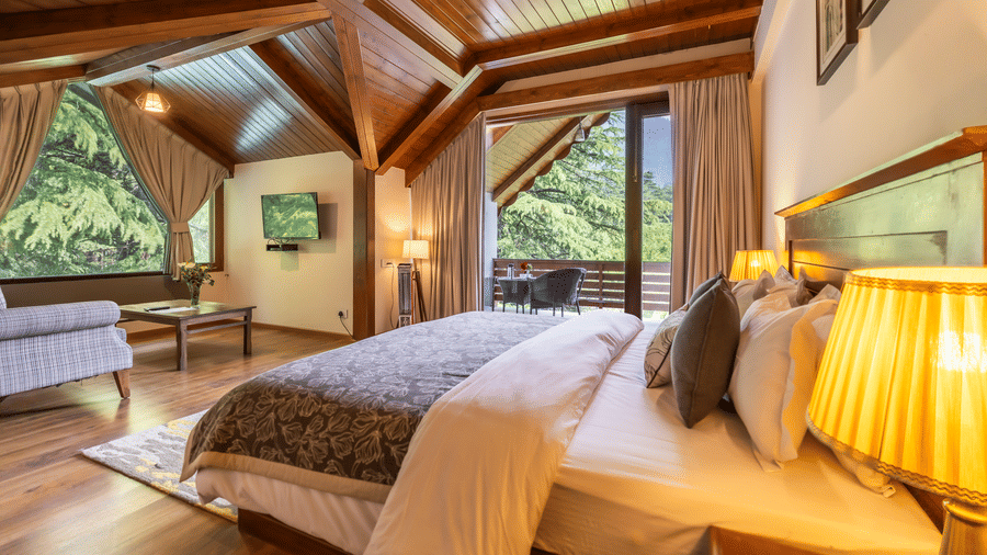 Premium room with queen bed and sofa setting and lavish wooden interiors at Bedzz Xclusiv Bikunth,Manali