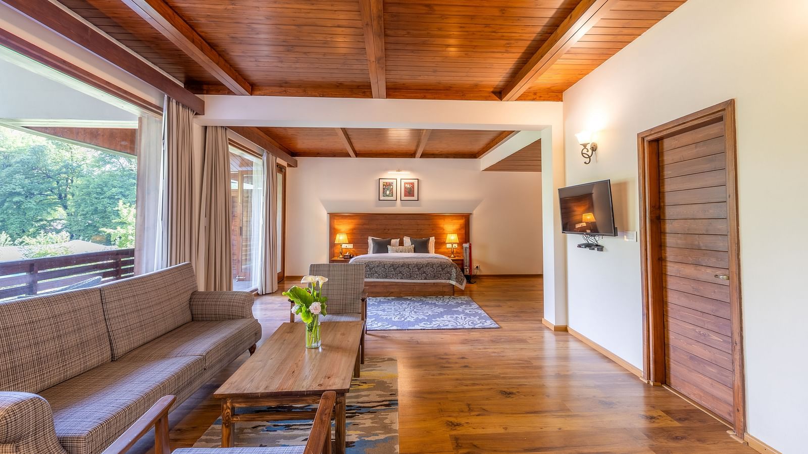 the xclusive room with lavish wooden interiors with a sofa and queen bed at Bedzzz Xclusiv Baikunth