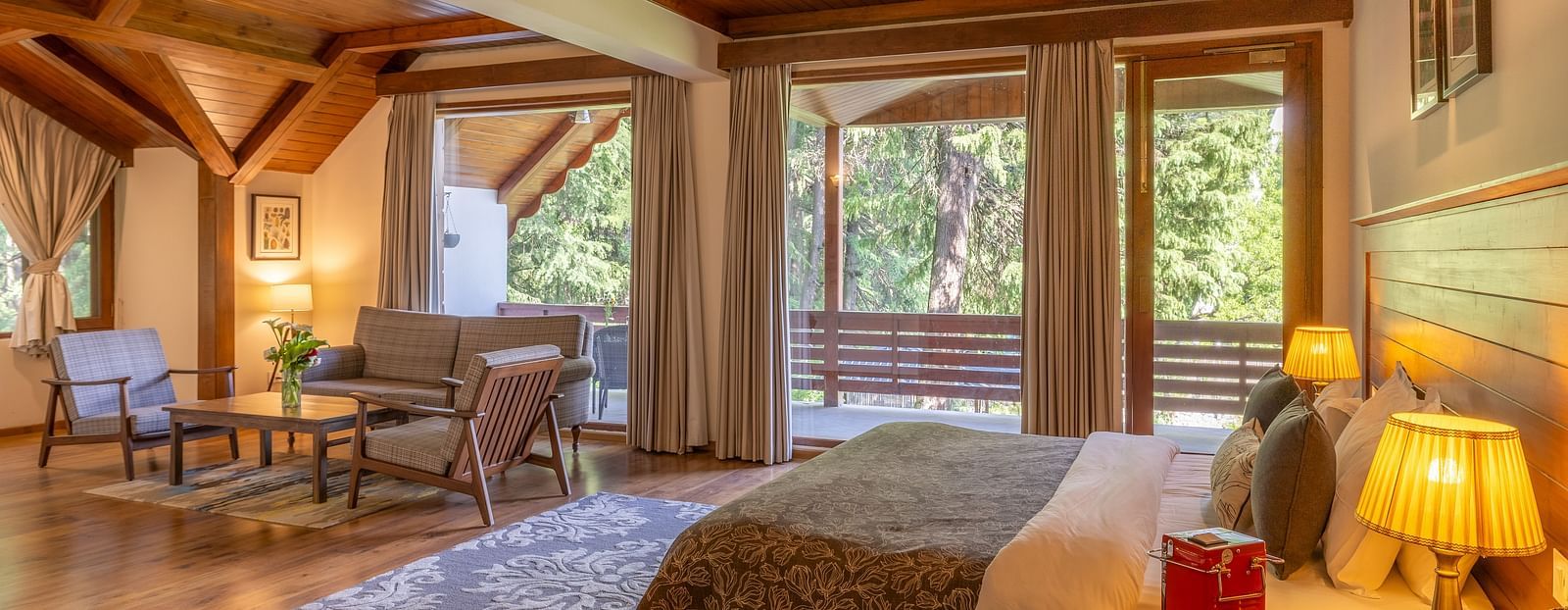 xclusiv room with queen bed and a sofa setting with lavish wooden interiors at Bedzz Xclusiv Baikunth, Manali