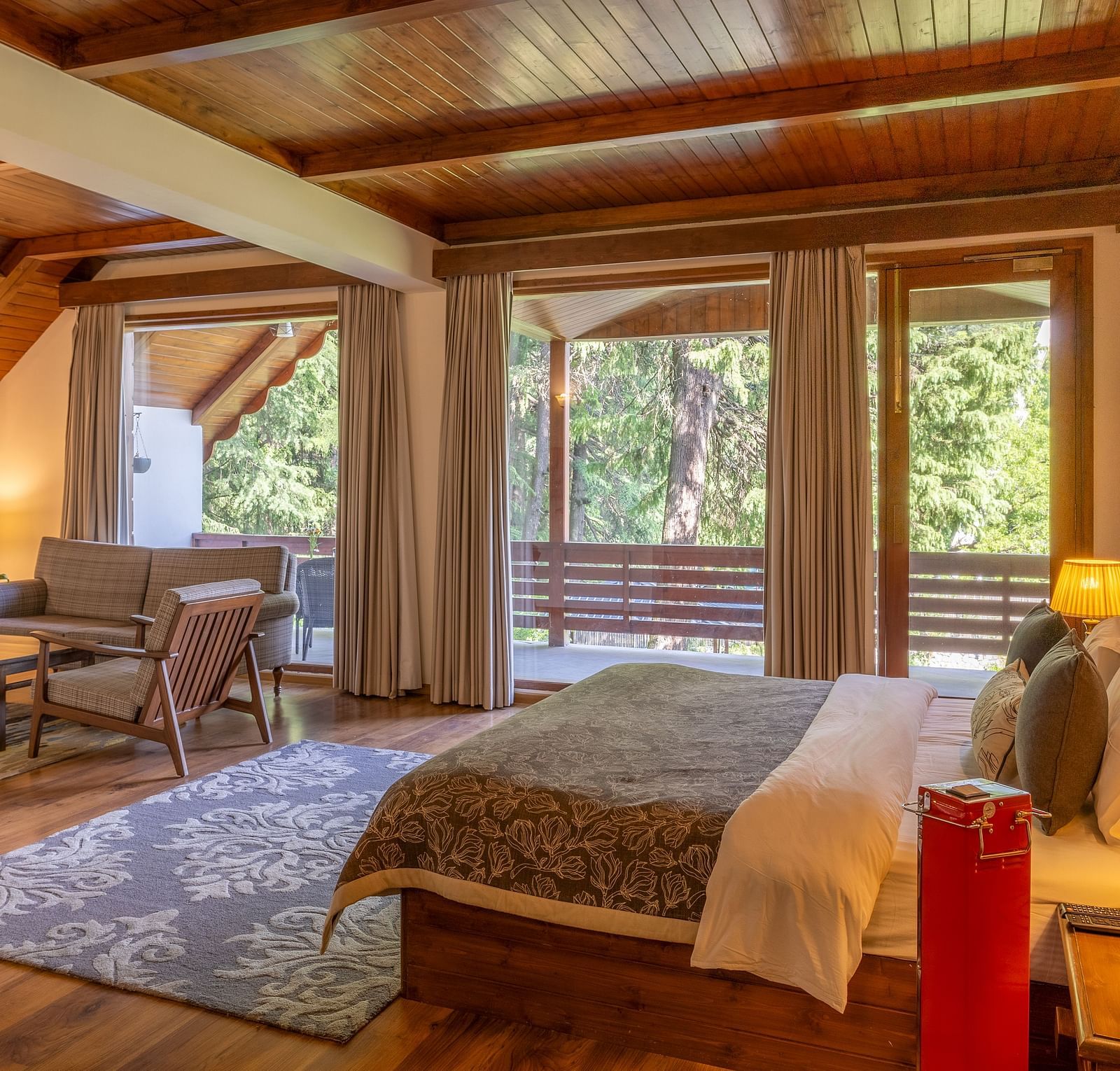 the xclusive room with lavish wooden interiors with a comfortable chairs and queen bed at Bedzzz Xclusiv Baikunth