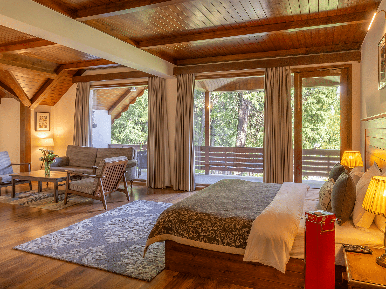 xclusiv room with queen bed and a sofa setting with lavish wooden interiors at Bedzz Xclusiv Baikunth, Manali