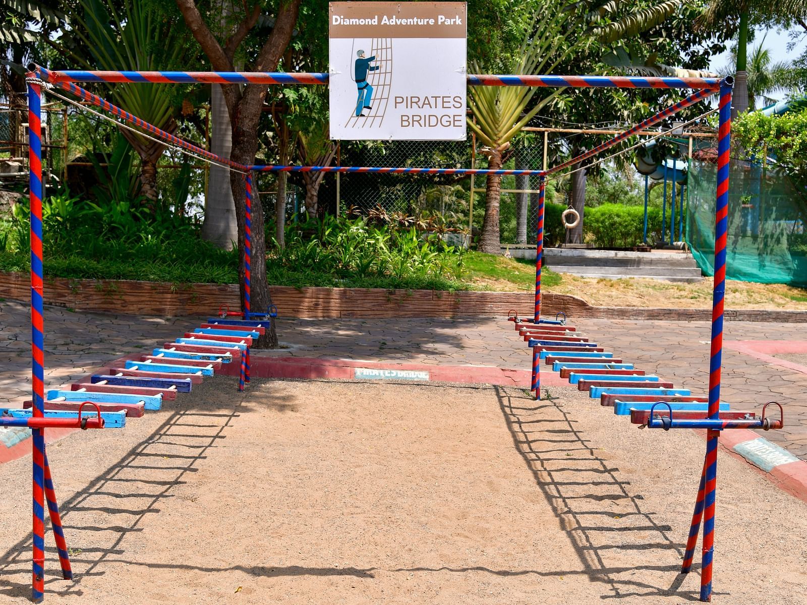 Outdoor playground with traditional swings set in a park under clear blue skies | Diamond Parks, Pune