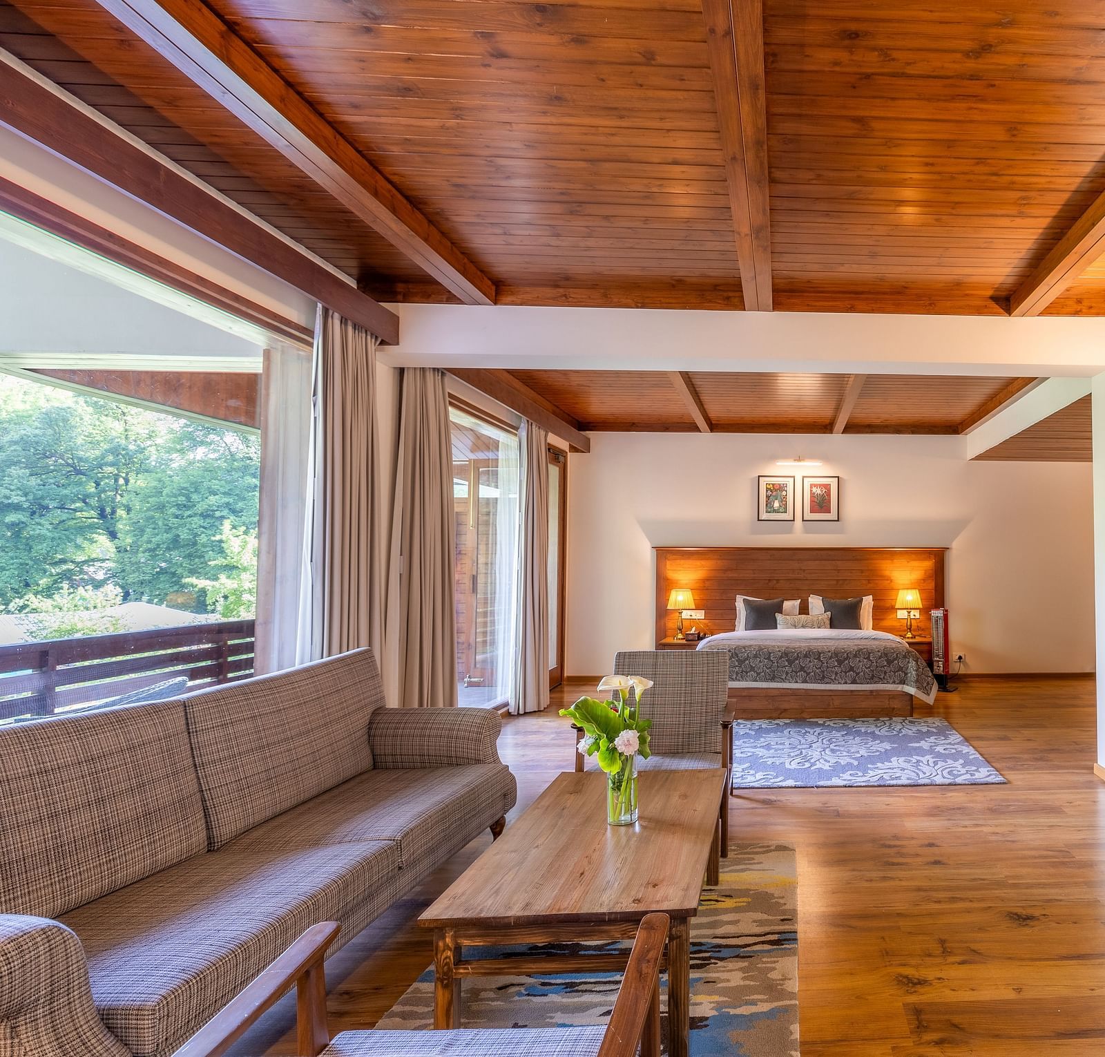 the xclusive room with lavish wooden interiors with a sofa and queen bed at Bedzzz Xclusiv Baikunth