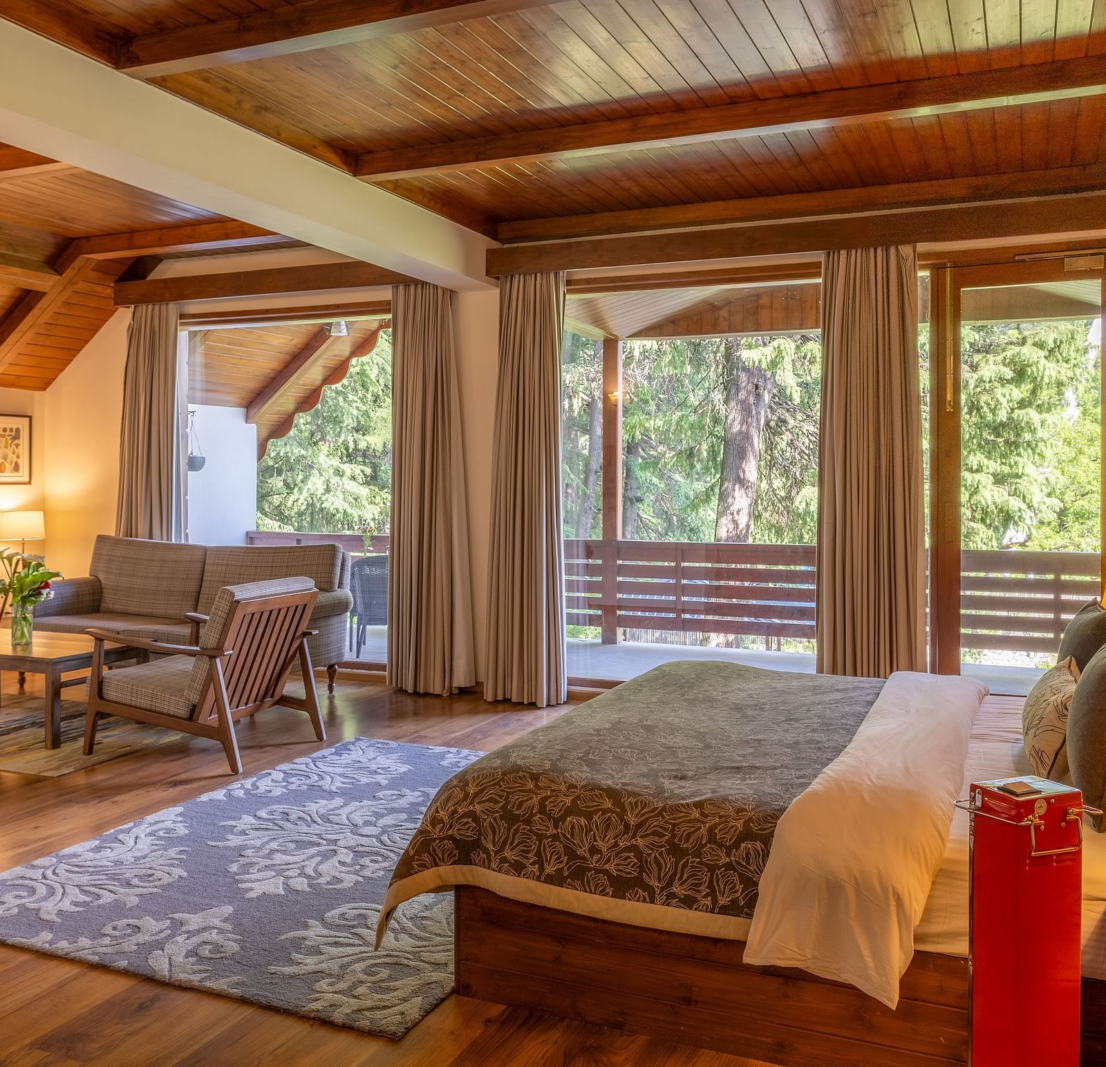 xclusiv room with queen bed and a sofa setting with lavish wooden interiors at Bedzz Xclusiv Baikunth, Manali