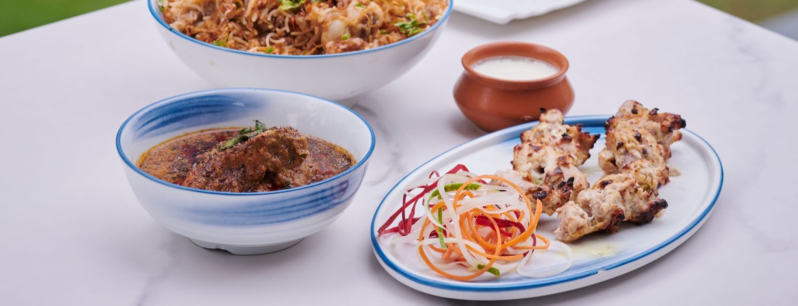 Plates of food on a table including rice, salad, curry, and side dishes at Grande Bay Resort & Spa.