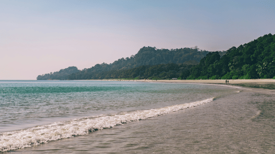 A view of Radhanagar Beach with a mountain in the background, it is one of the perfect places for Weekend Getaways from Chennai.
