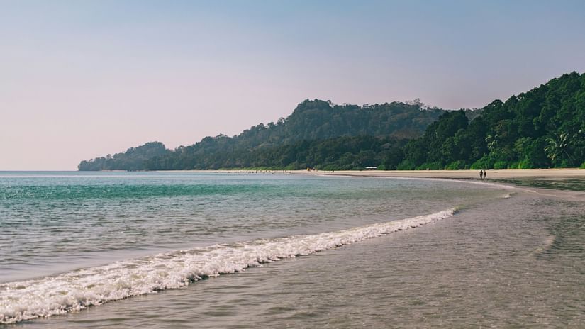 A view of Radhanagar Beach with a mountain in the background