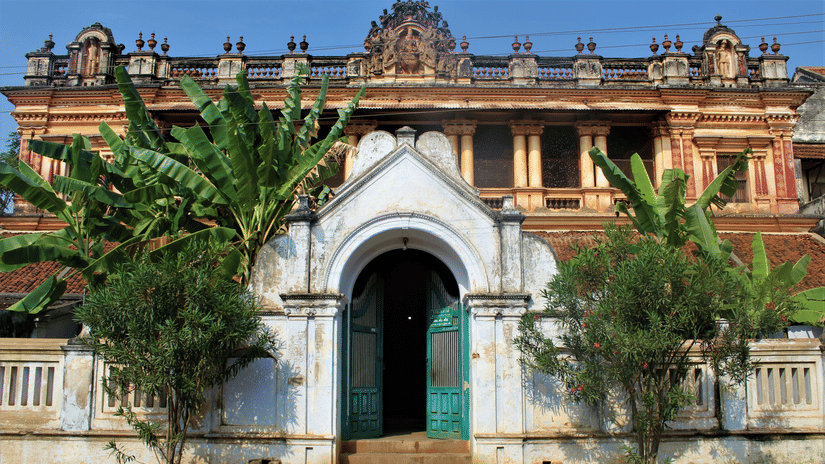 A large, ornate building with a grand arched entrance and a vibrant blue door.