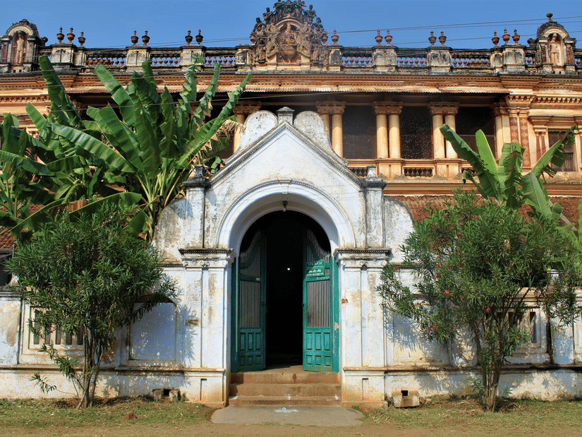 A large, ornate building with a grand arched entrance and a vibrant blue door.