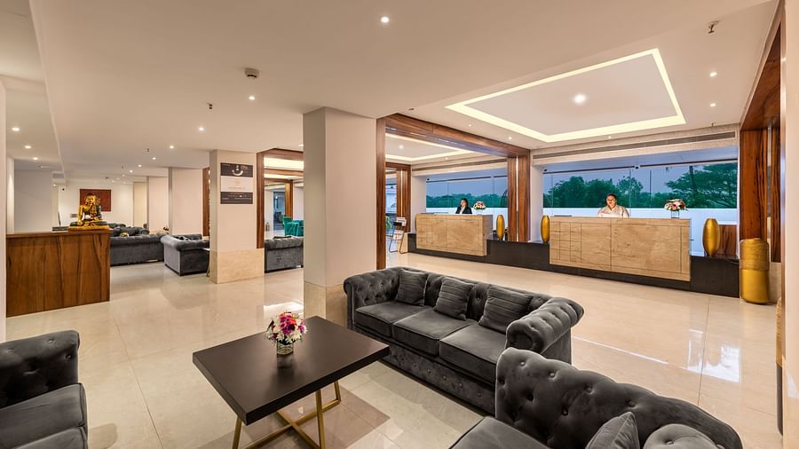 A lobby area featuring three big sofas, a coffee table, a help desk, and big glass windows - Golden Tulip, Candolim, Goa