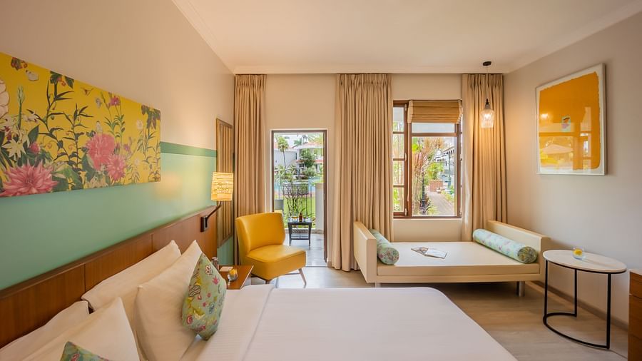 room with a king size bed and vibrant yellow interiors at Heritage Village Resorts and spa